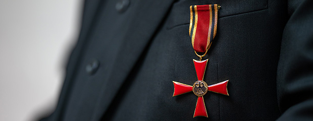 Das Verdienstkreuz am Bande, getragen von einem Mann mit Anzug