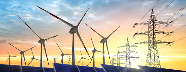 Windkrafträder, Solaranlage und Stromtrasse im Sonnenaufgang