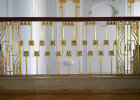 Detailansicht des goldenen Treppengeländers mit geometrischen Formen